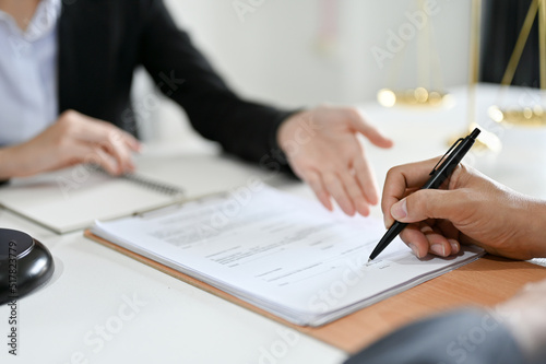 Cropped, A male client signs his signature on the law contract in front of the lawyer