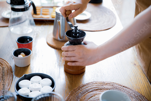 コーヒーミルでコーヒー豆を挽く女性の手