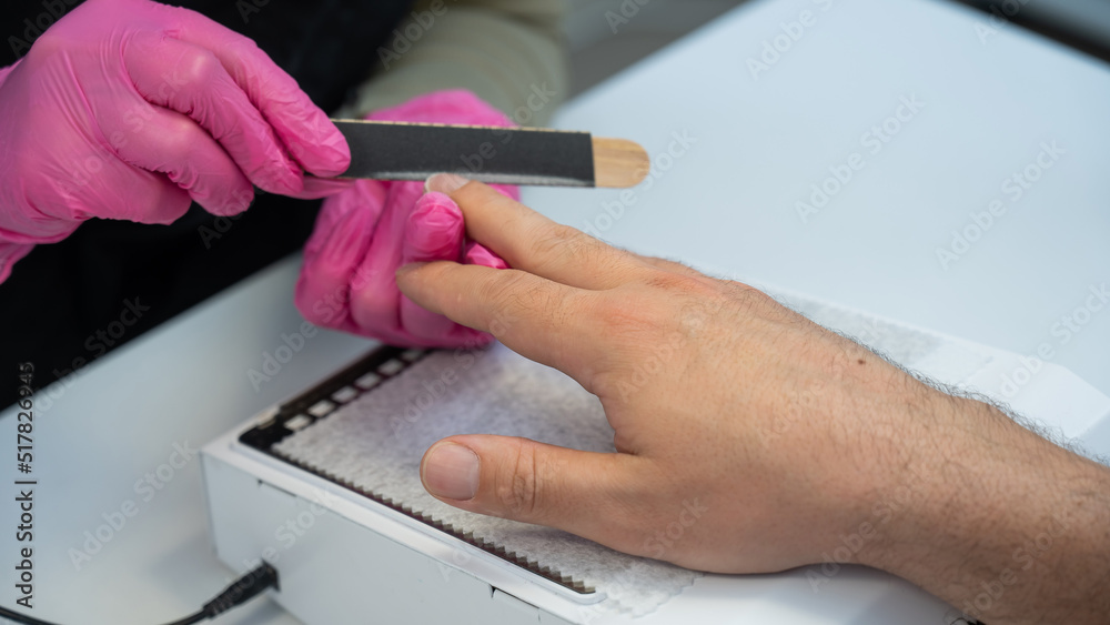 Man on a manicure procedure in a beauty salon. 