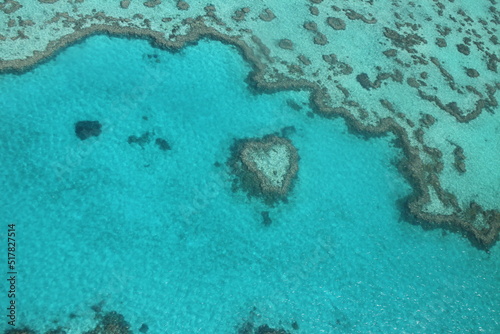 Heart reef view from the sky. Great barrier reef scenic flight in Australia. Blue water and corals forms.
