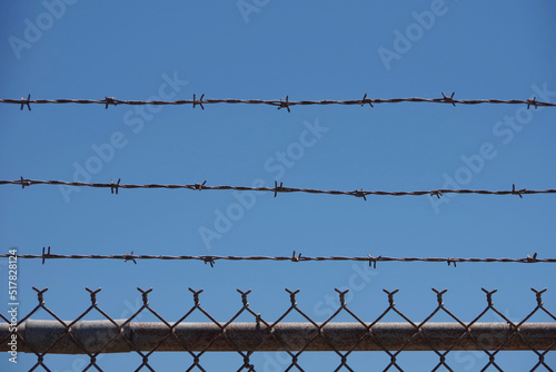 Section of chainlink security fence with barbed wire