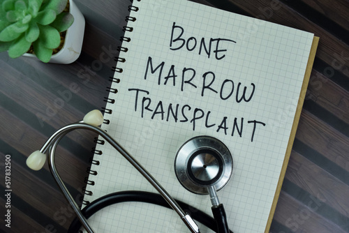 Concept of Bone Marrow Transplant write on a book with stethoscope isolated on Wooden Table. photo