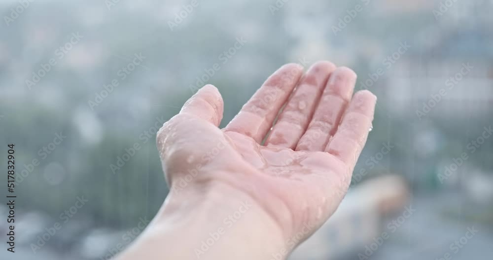 POV hand under heavy rain in summer, closeup. Person enjoying rainy weather. Rain drops in female palm on blur street nature background. Summer warm abstract rain. Wet human arm in rain droplets. 4k POV hand under heavy rain in summer, closeup. Person enjoying rainy weather. Rain drops in female palm on blur street nature background. Summer warm abstract rain. Wet human arm in rain droplets. 4k