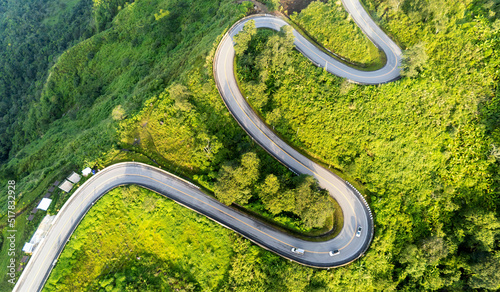 Aerial top view drone photo over green mountains with white fog floating and  paths exciting steep road way of travel at Phu Thap Boek ,Phetchabun,Thailand. photo