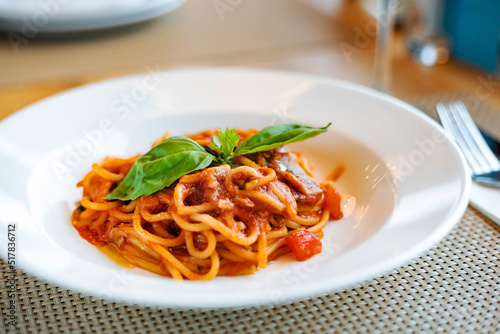 Italian cuisine. spaghetti bolognese with meat, parmesan cheese and tomatoes on white plate.
