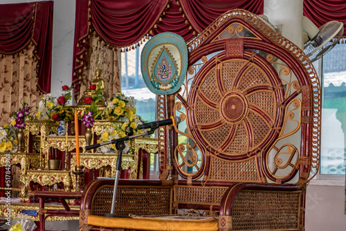 The empty decorative chair for the abbot of Buddhist monastery with microphone ready for ceremonies, Thailand. photo