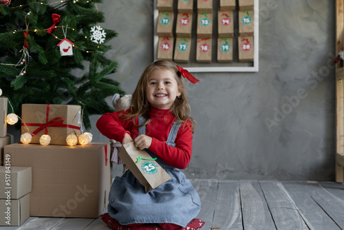 Happy child with handmade advent calendar gift package with candy, Christmas children's fan