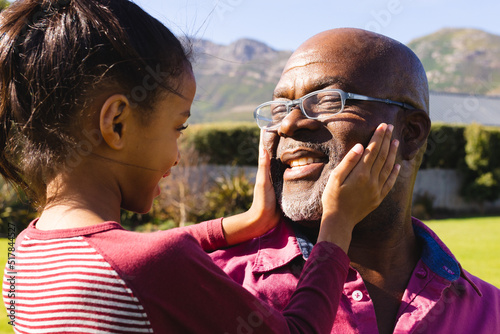 Canvas Print Biracial granddaughter touching smiling african american bald grandfather's face