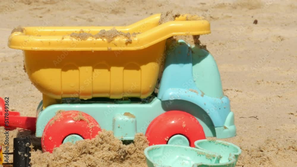 multi-colored plastic toys on a large sea sandy beach multi-colored plastic toys on a large sea sandy beach