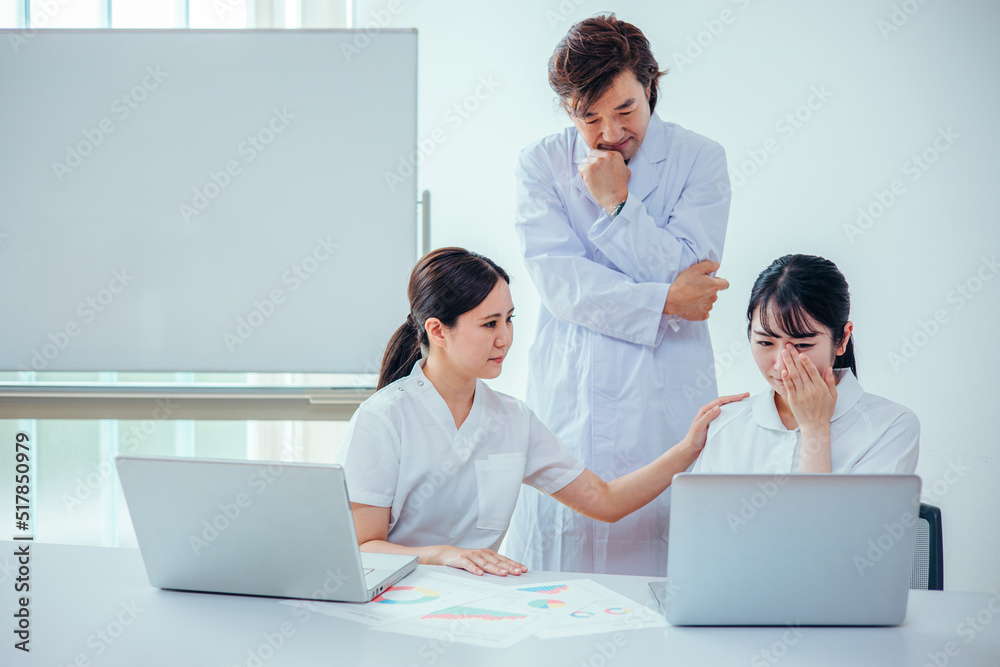 泣く看護師を励ます医者とナース
泣く看護師を励ます医者とナース