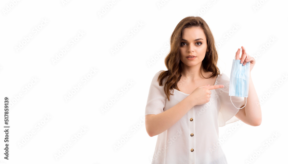 The girl points her finger at the medical mask. The girl points her finger at the medical mask.