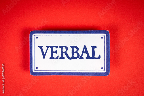 VERBAL. Text on white sticky note. Red background