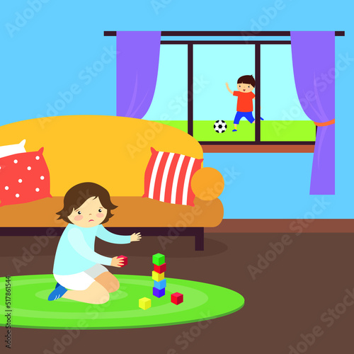 The boy sadly plays cubes at home while other children play football on the street