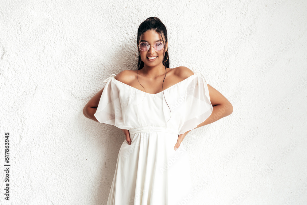 Young beautiful smiling female in trendy summer dress clothes. Sexy carefree woman posing near white wall in studio. Positive model having fun and going crazy. Cheerful and happy. In sunglasses Young beautiful smiling female in trendy summer dress clothes. Sexy carefree woman posing near white wall in studio. Positive model having fun and going crazy. Cheerful and happy. In sunglasses