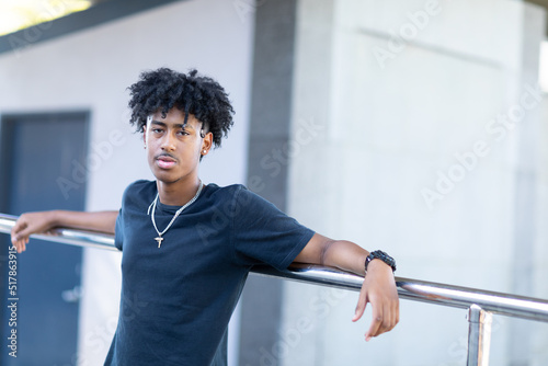 one young man in black tee leaning against railing
