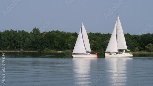 Nautisme sur le lac du Der Chantecoq, en Champagne Ardenne, dans la région Grand Est, avec deux bateaux à voile blancs naviguant sur l’eau bleue du lac (France)