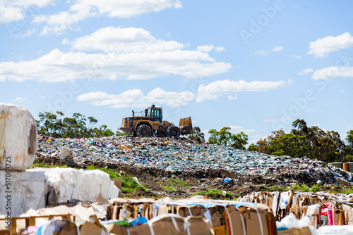 Council tip with machinery working in piles of waste photo