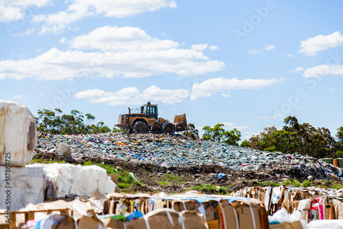 Council tip with machinery working in piles of waste
