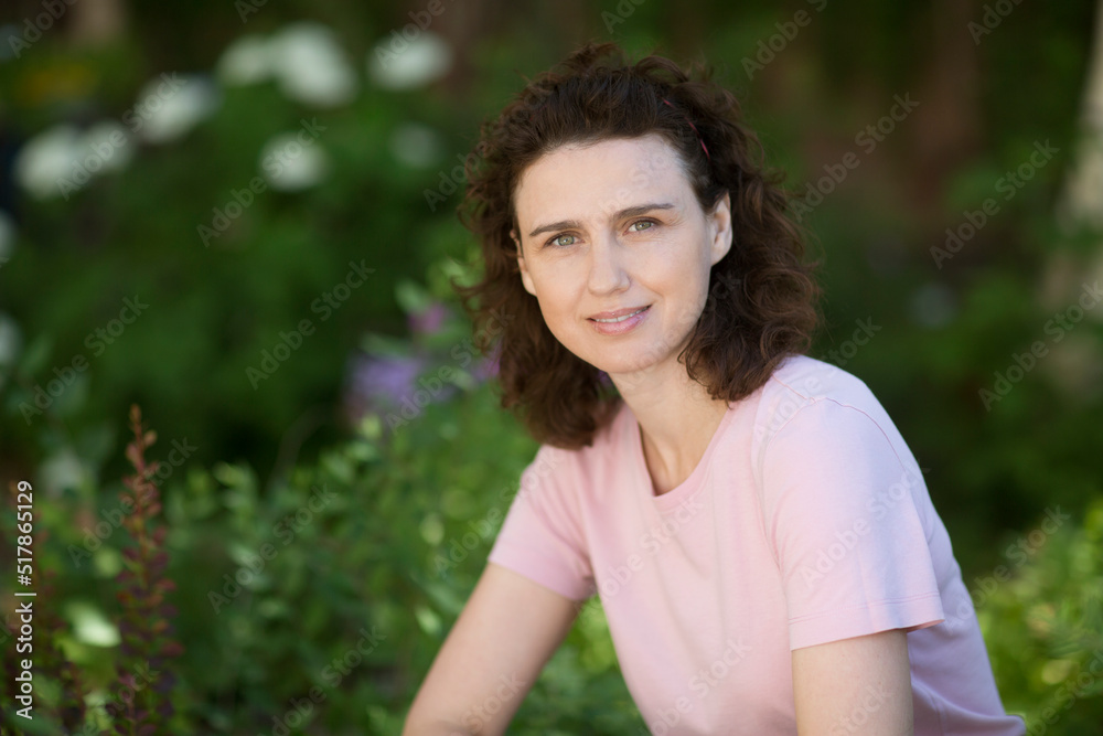 portrait middle aged woman in garden with mixed green fresh aromatic herbs near the house. portrait middle aged woman in garden with mixed green fresh aromatic herbs near the house.