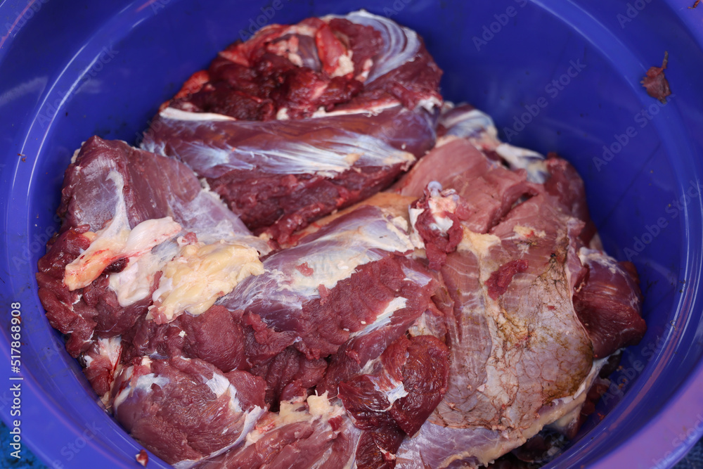 Making the process of tasty fresh beef meat. close up and texture of Traditional Red beef meat. Meat food background. White, blue, red, and black bucket