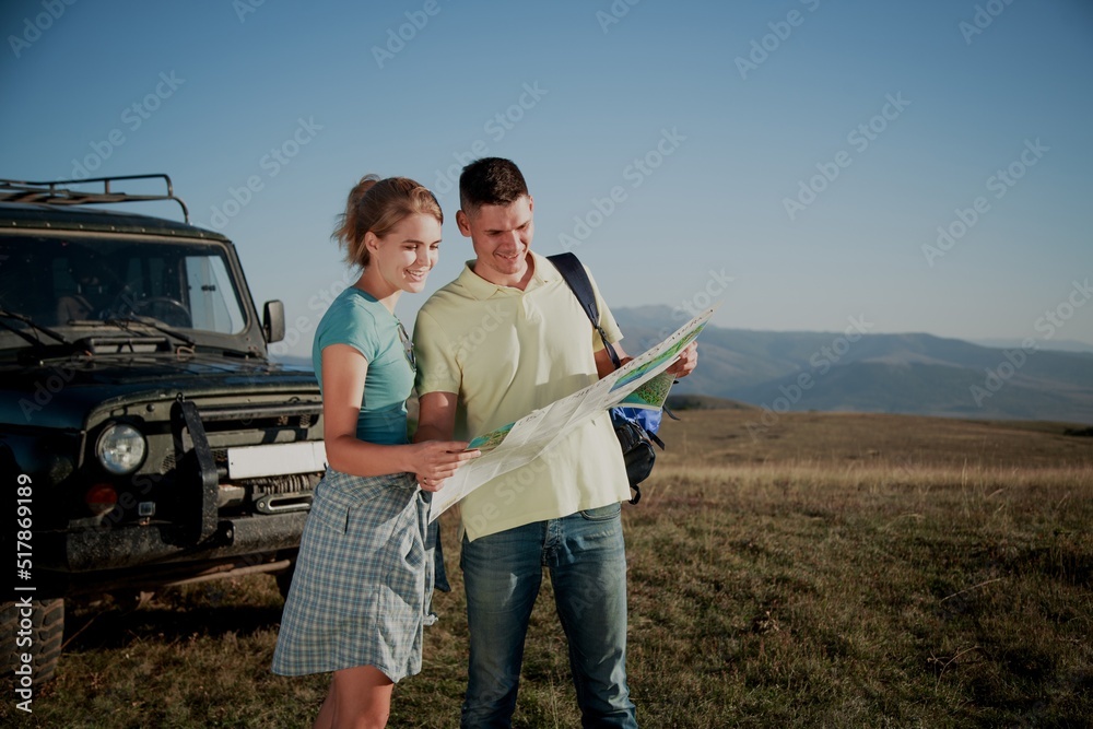 Couple of hikers planning next way to holding map during travel