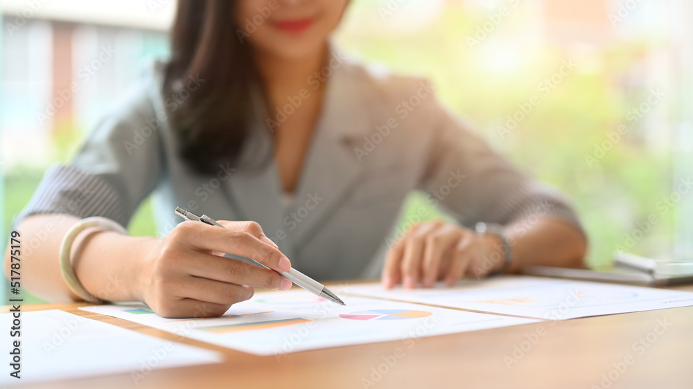 Cropped image of businesswoman examining the numerical data on financial document Cropped image of businesswoman examining the numerical data on financial document