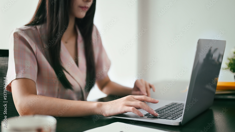 Cropped shot of working woman typing business email, searching information on laptop computer Cropped shot of working woman typing business email, searching information on laptop computer
