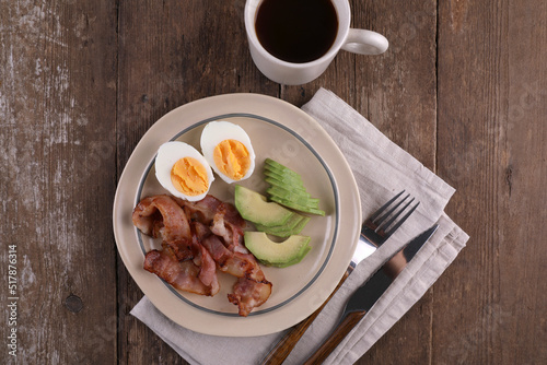 Breakfast with bacon, eggs and coffee on a wooden table
