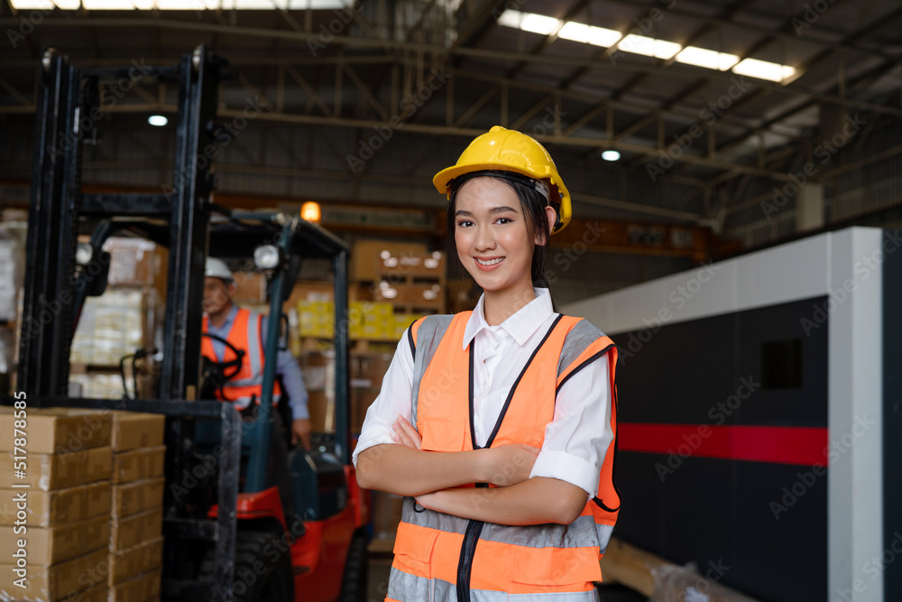 Portrait of female staff smiling with holding clipboard standing in warehouse with looking at camera, Industrial and industrial workers concept. Portrait of female staff smiling with holding clipboard standing in warehouse with looking at camera, Industrial and industrial workers concept.