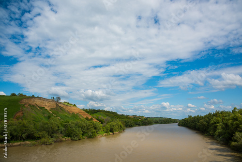 Summer rural landscape. River and high steep banks