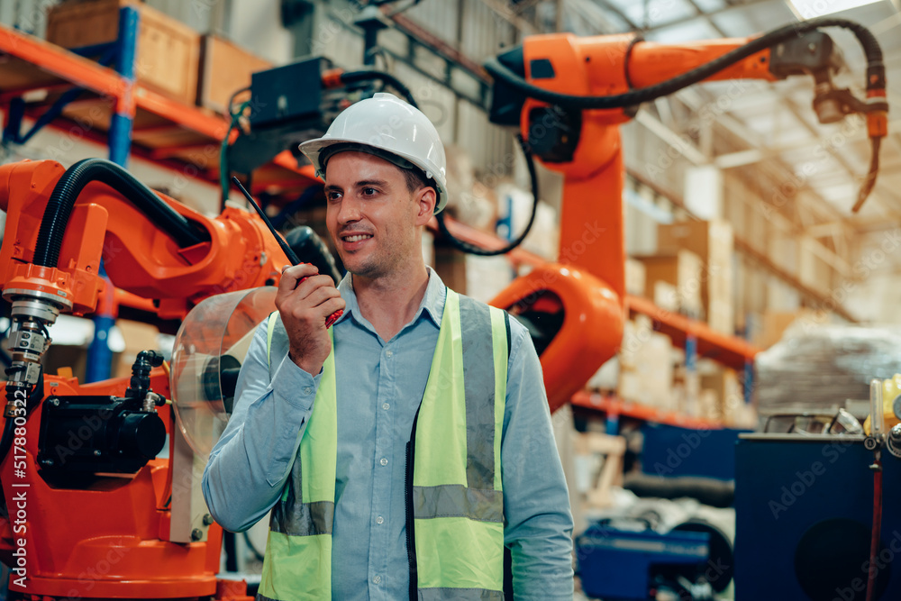 Male engineer checking and inspection control a robot arm machine welding steel in an industrial factory, Fast and highly secure. Male engineer checking and inspection control a robot arm machine welding steel in an industrial factory, Fast and highly secure.