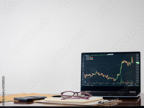 Laptop investing graph on working table copy space white background
