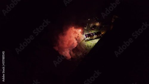 On news fire incident in night city. Aerial drone shot firefighters professional team putting out burning fire. Cinematic movie clip. Filming area.