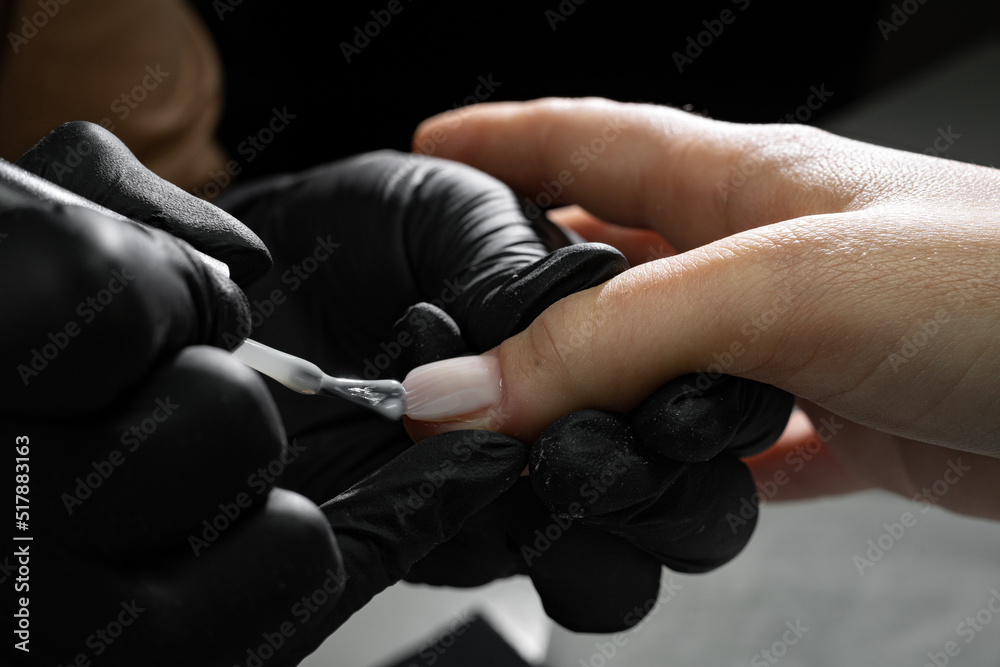 Close up manicure nail paint with thin brush, nails artist polish, modelation gel. Beautician salon, manicure procedure