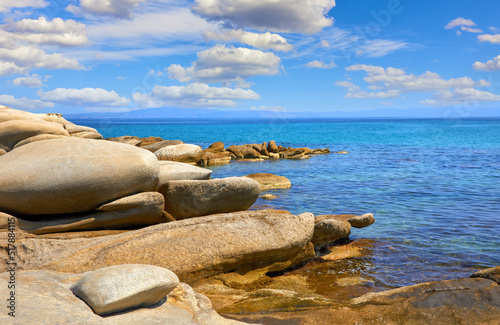 Karidi beach at peninsula Sithonia, Chalkidiki, Greece. Big stones coastline of Aegean sea with blue water. Sea view at famous mountain Athos Agion Oros (Holy Mountain). Summer sunny day sky clouds. © Yasonya