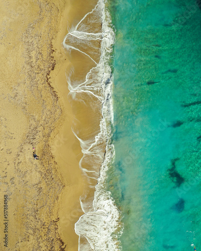 Aerial view of huge beach with waves crashing on the sand