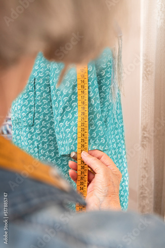 unrecognizable older woman sizing a turquoise garment