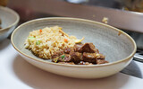 Rindfleisch mit Reis auf einem Teller.
