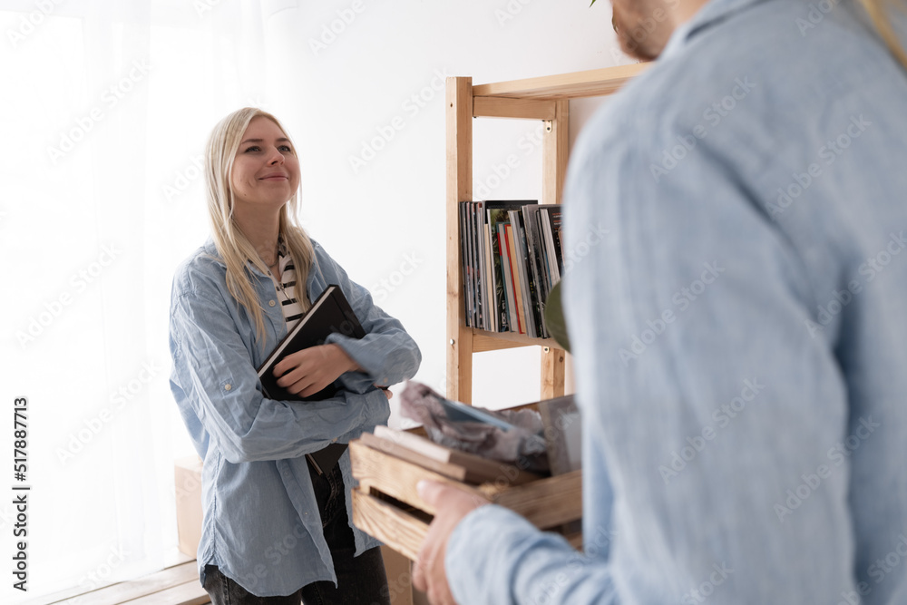Obraz premium Young couple moving into a new apartment or house together, moving day a young family to a new home, relocation and people