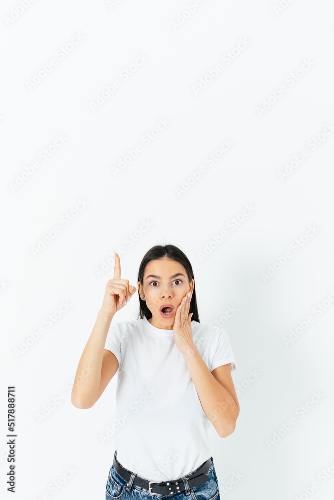 Amazed young woman pointing her finger up Amazed young woman pointing her finger up