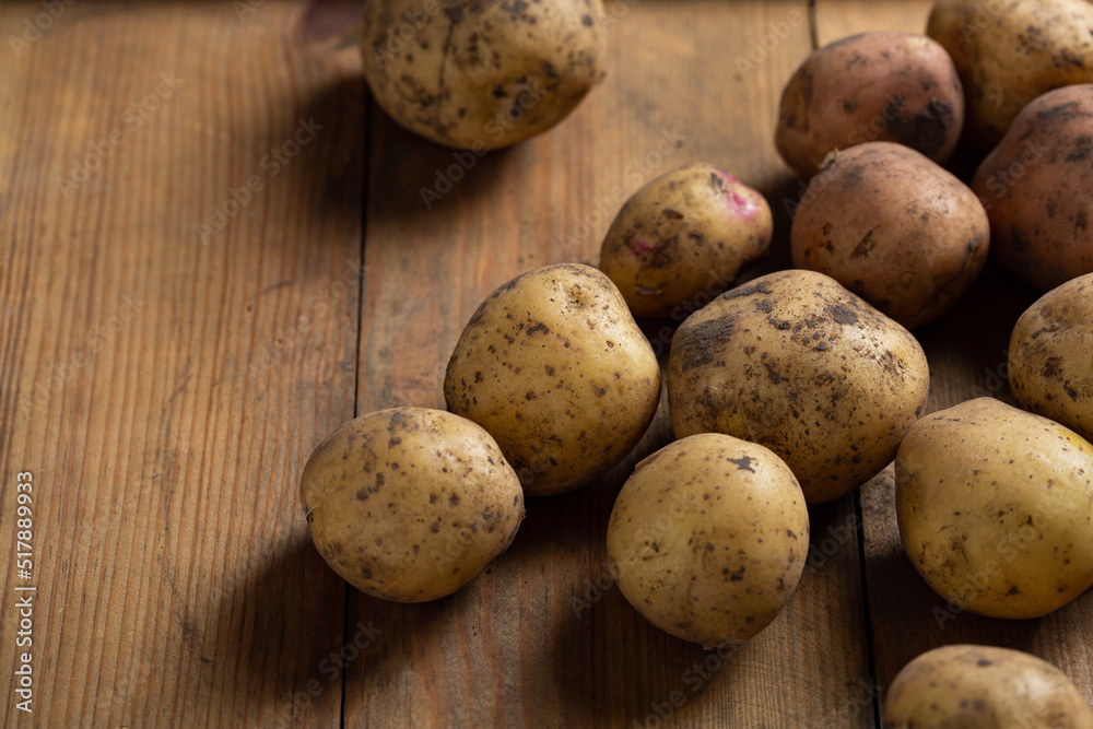 Fresh potatoes roots close up on wooden background Fresh potatoes roots close up on wooden background