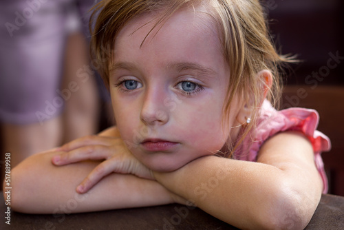 Portrait of a beautiful little girl child with reddened face and tired sad expression, feeling unwell in case of allergic reaction