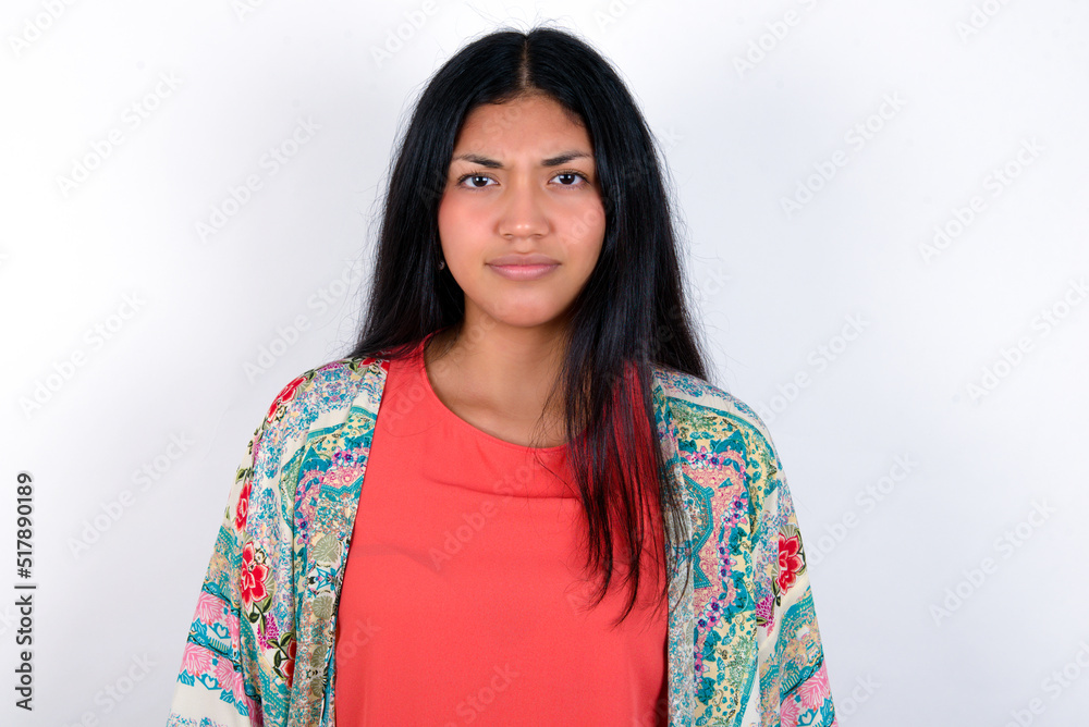 young brunette woman wearing colourful outfit standing against white background Pointing down with fingers showing advertisement, surprised face and open mouth young brunette woman wearing colourful outfit standing against white background Pointing down with fingers showing advertisement, surprised face and open mouth
