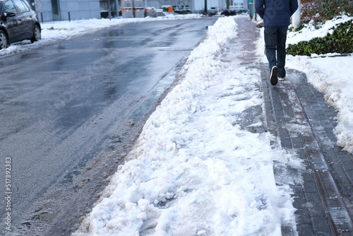 part of street in city, pavement after heavy snowfall, wet snow melts, puddles, slush and mud impede movement of pedestrians and vehicles, concept traffic safety, work of public utilities © kittyfly