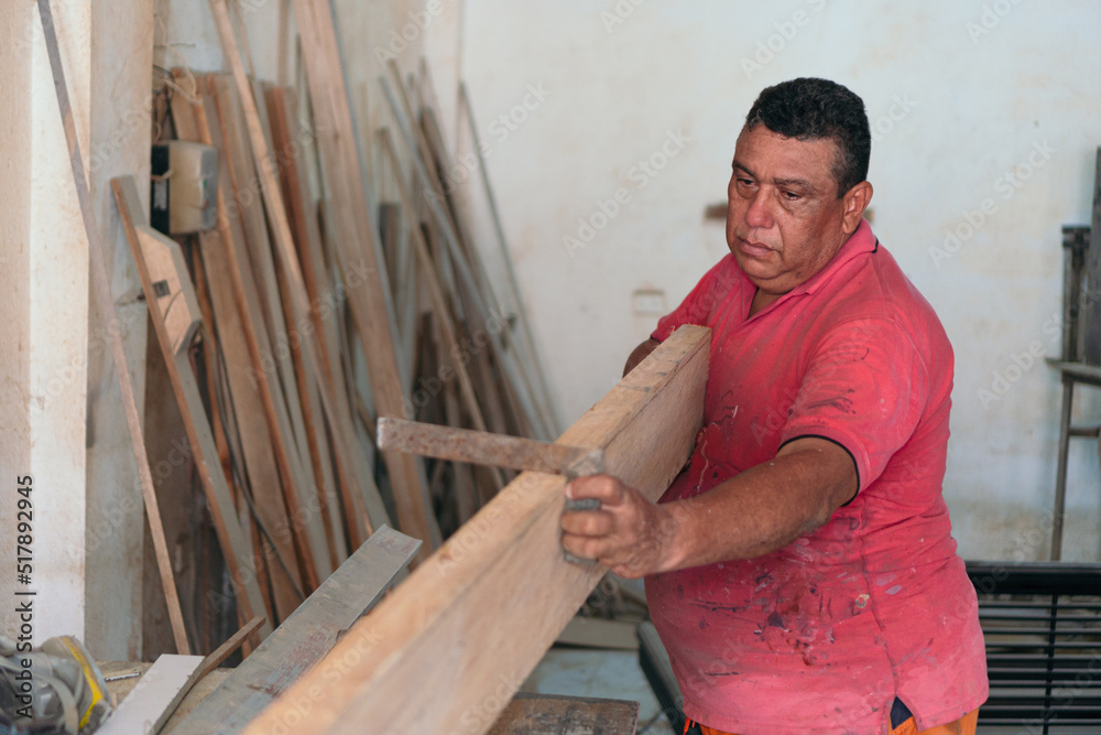 Mature carpentry shop owner working with wood Mature carpentry shop owner working with wood