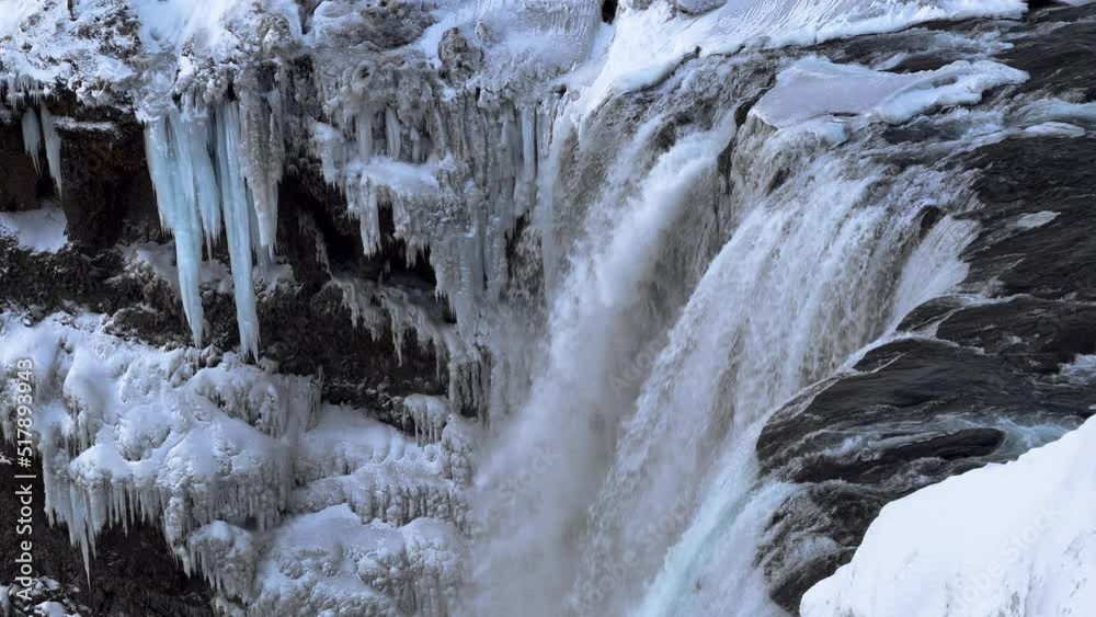 Slow motion shot of giant deluge of water flowing down icy waterfall in Iceland Slow motion shot of giant deluge of water flowing down icy waterfall in Iceland