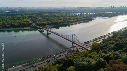 Drone aerial view Kyiv pedestrian bridge, Truchaniv island and Dnieper river on a beautiful sunny spring day. Capital of Ukraine