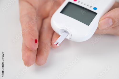 Woman measures blood sugar level with a glucometer. 