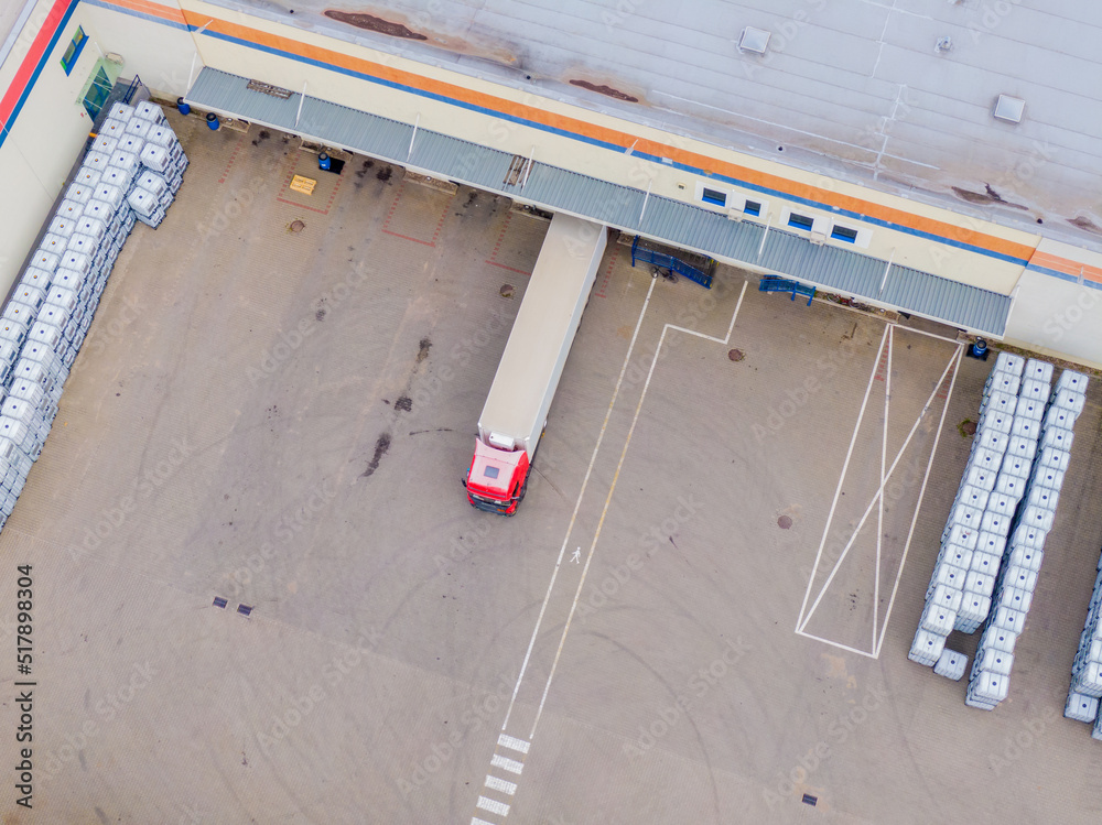 Aerial view of goods warehouse. Logistics center in industrial city zone from above. Aerial view of trucks loading at logistic center Aerial view of goods warehouse. Logistics center in industrial city zone from above. Aerial view of trucks loading at logistic center