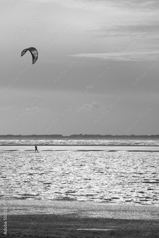 A kitesurfer rides across the north sea in strong winds A kitesurfer rides across the north sea in strong winds